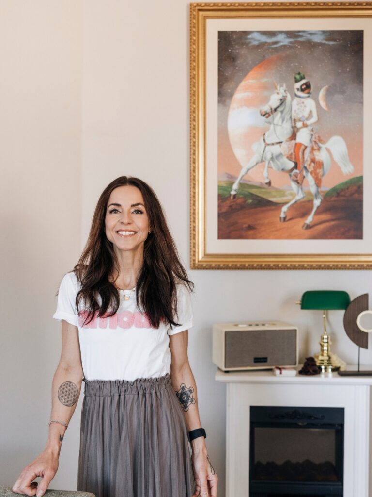 Saida Thenhart in der Praxis Ad Astra Lab in Würzburg neben einem Astronauten-Gemälde